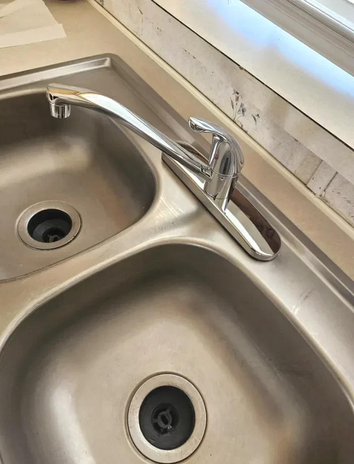 New kitchen faucet installed on a stainless steel sink