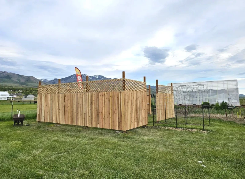 Completed cedar privacy fence with lattice top enclosing a garden in Cache Valley
