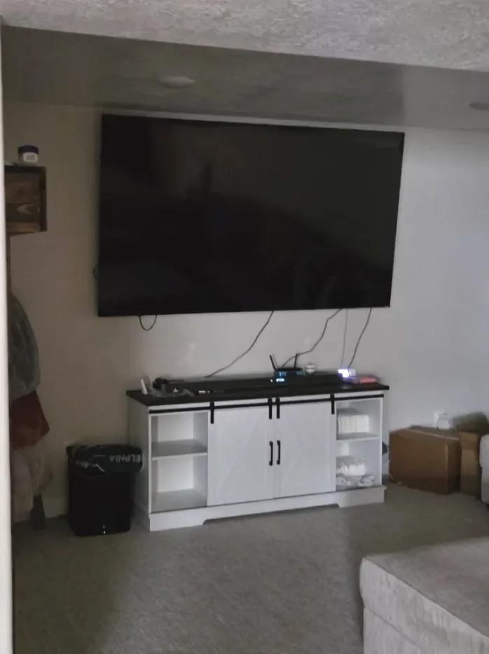 Large flat-screen TV securely wall-mounted above a media console